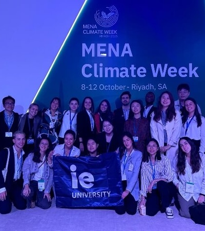 A group of people posing with a banner at the MENA Climate Week event in Riyadh.