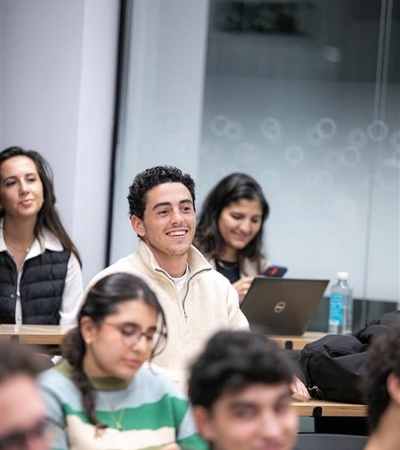 A group of students attentively listening in a classroom setting.