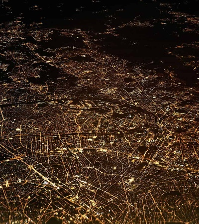 Aerial view of a city at night illuminated by street lights and buildings.