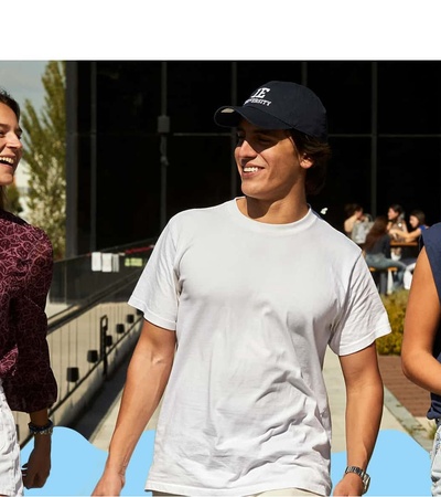 Three young people are walking together outdoors, smiling and enjoying their time.