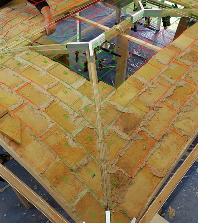 This image shows a detailed view of a tiled roof structure in progress, highlighting its intricate patterns and construction techniques.