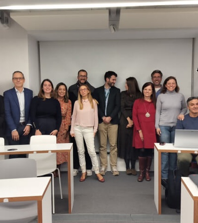 A group of people standing and smiling in a classroom setting.