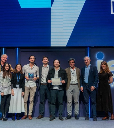 A group of people presents awards on stage at an event.