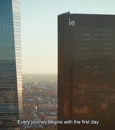 A skyline view featuring modern buildings with the text 'Every journey begins with the first day' visible.