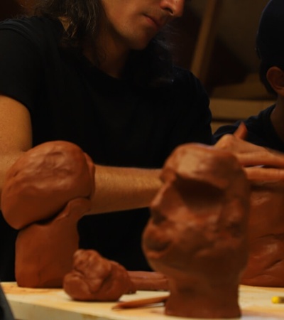 People sculpting with clay at a workshop.