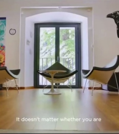 An interior space featuring modern chairs and a small table, with a large crow mural on the wall