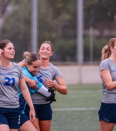 A group of female soccer players celebrating on the field.