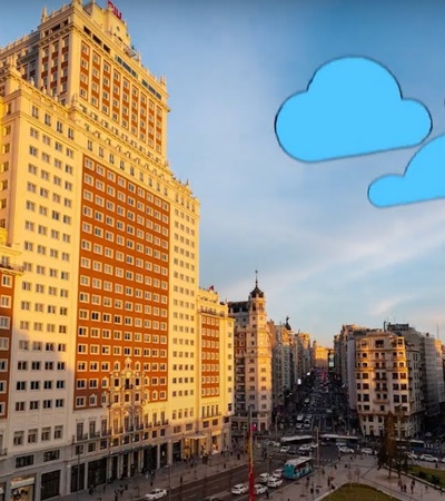 Aerial view of a bustling city intersection with historic high-rise buildings during sunset, adorned with simple cartoon clouds in the sky.