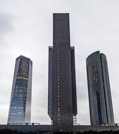A skyline featuring several modern skyscrapers under a cloudy sky.