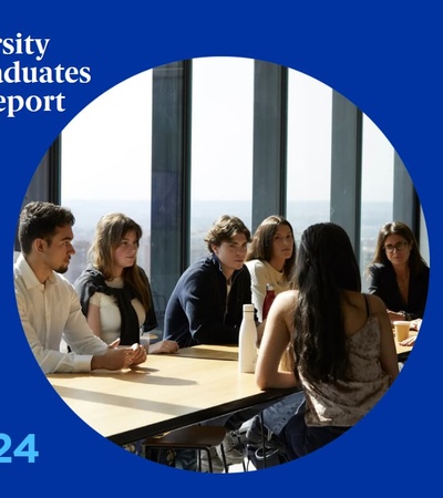 A group of students sitting at a table in a modern classroom setting.