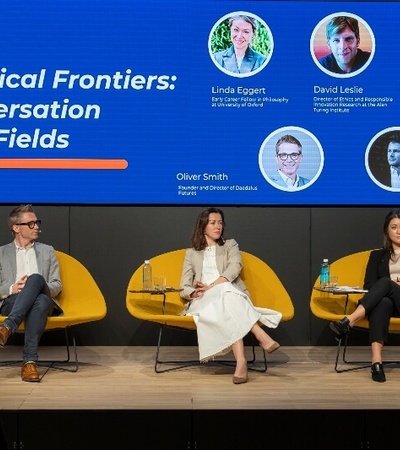 Five panelists are participating in a discussion titled 'AI's Ethical Frontiers: A Conversation across Fields' at a conference.