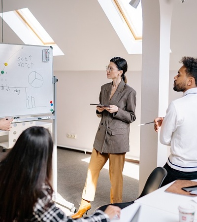 A woman doing a presentation at a whiteboard.