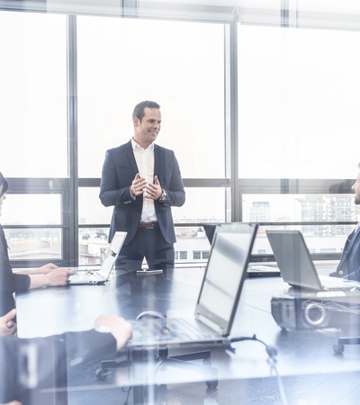 A businessman giving a presentation to a group in a modern conference room.