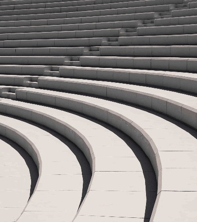 A grayscale image of curved concrete steps forming an open-air amphitheater.