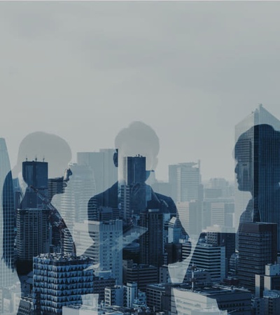 in the point of view of a skyscraper different buildings can be seen from the heights and some business people's figures reflected like they were in front of a glass, representing different family economic businesses
