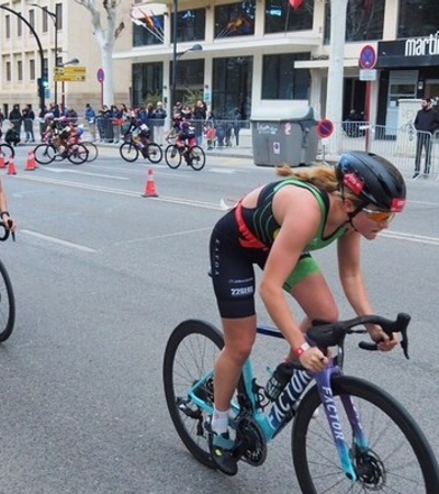 Female athletes competing in a cycling race on an urban road.