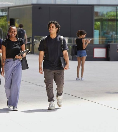 A group of diverse young adults walking together in a bright outdoor setting.