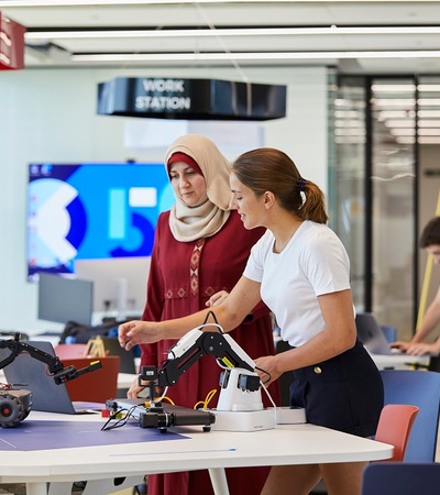 Two women with a robot