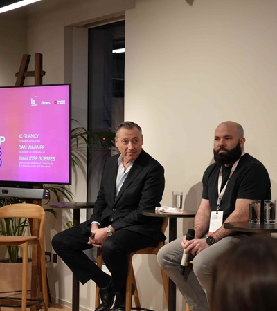 A panel discussion featuring three speakers in a modern setting.