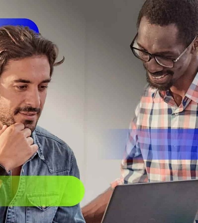 Two men, one looking at a tablet and discussing something with a coworker.