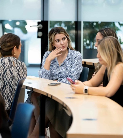 A group of people engaged in discussion in a classroom setting.
