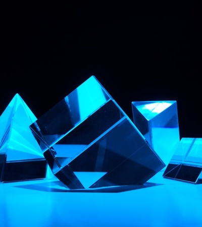 A collection of transparent geometric shapes illuminated with blue light.