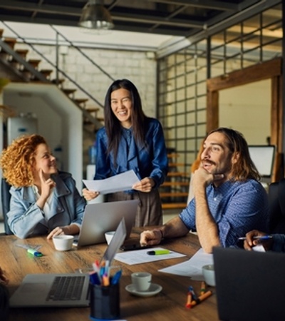 A diverse group of people engaged in a lively discussion around a table in a modern office.