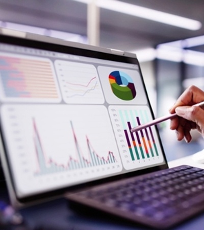 A person using a touchscreen laptop to analyze data visualizations and graphs.