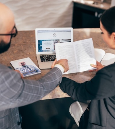 A business meeting taking place with two professionals discussing a document.