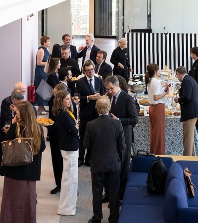 A group of business professionals networking at a conference event in a modern venue.