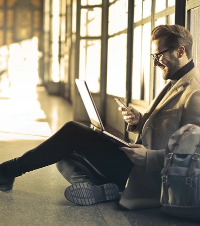 Man with a computer sitting on the floor 