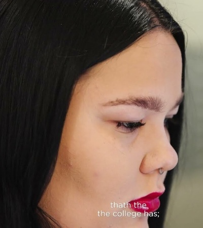 Close-up of a young woman with dark hair looking down, with subtitled text on the image.