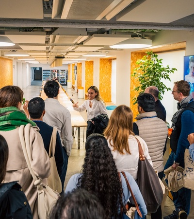 A diverse group of people attending a presentation in a modern workspace.