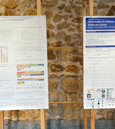 The image shows two academic posters displayed on a stone wall, one discussing optimization and the other about scheduling in healthcare.