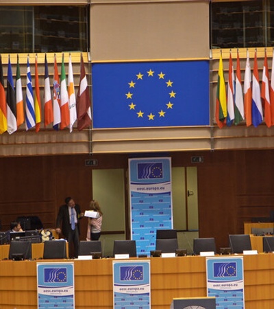 A conference room featuring multiple national flags and the European Union flag.