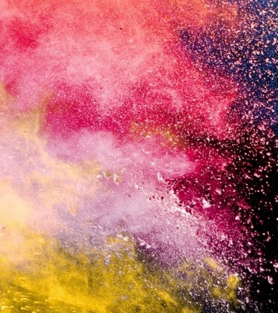 Colorful explosion of powder particles on a dark background
