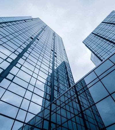 Low angle view of modern glass skyscrapers with reflections of clouds.