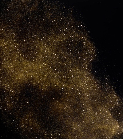 A beautiful swath of golden particles against a dark background resembling a galaxy.