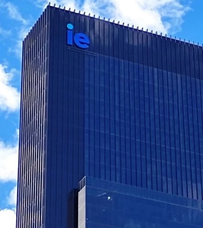 A modern skyscraper featuring the letters 'IE' prominently displayed at the top.