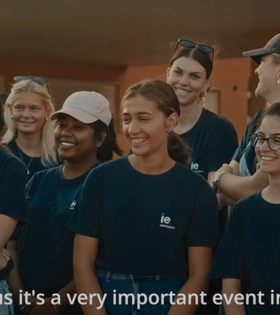 A group of people wearing matching blue shirts, smiling and attending an outdoor event.