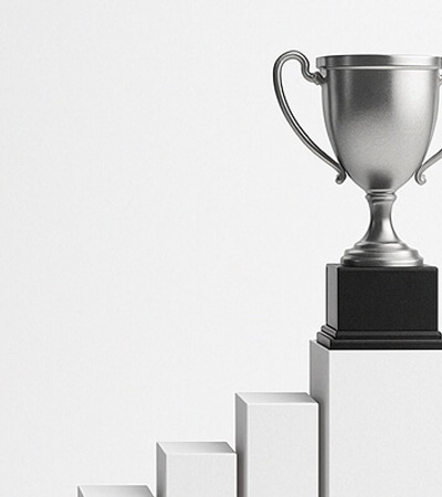 A silver trophy placed on a pedestal representing achievement.