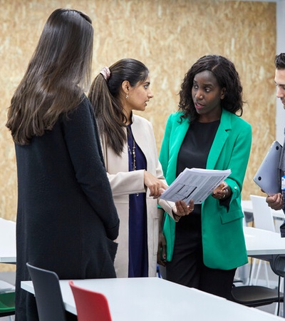 A group of professionals engaging in a discussion in a modern office space.