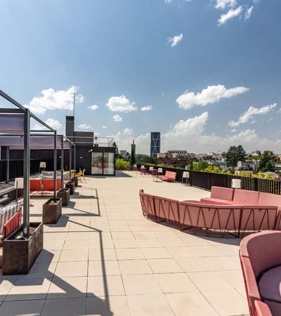 A modern rooftop terrace with stylish seating and a clear blue sky.