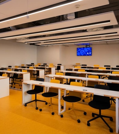 A modern classroom with multiple rows of desks and chairs arranged for students.