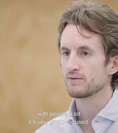 A person speaking in a conversation with a focused expression.