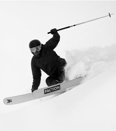 A skier in motion on a snowy slope, captured in a black and white image.