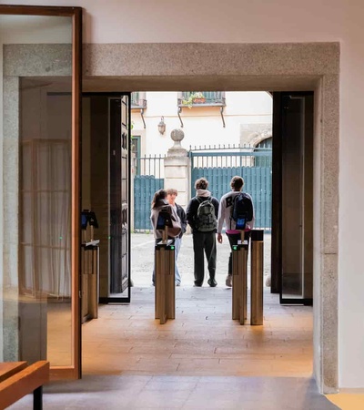 Three people are standing in an archway looking out onto a courtyard.