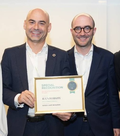 Four professionals smiling at a conference while one of them holds an award.