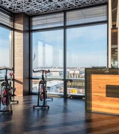 A bright and modern fitness area featuring stationary bikes and large windows with a view.