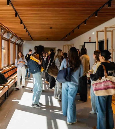 A group of people mingling in a bright, modern hall with wooden accents.